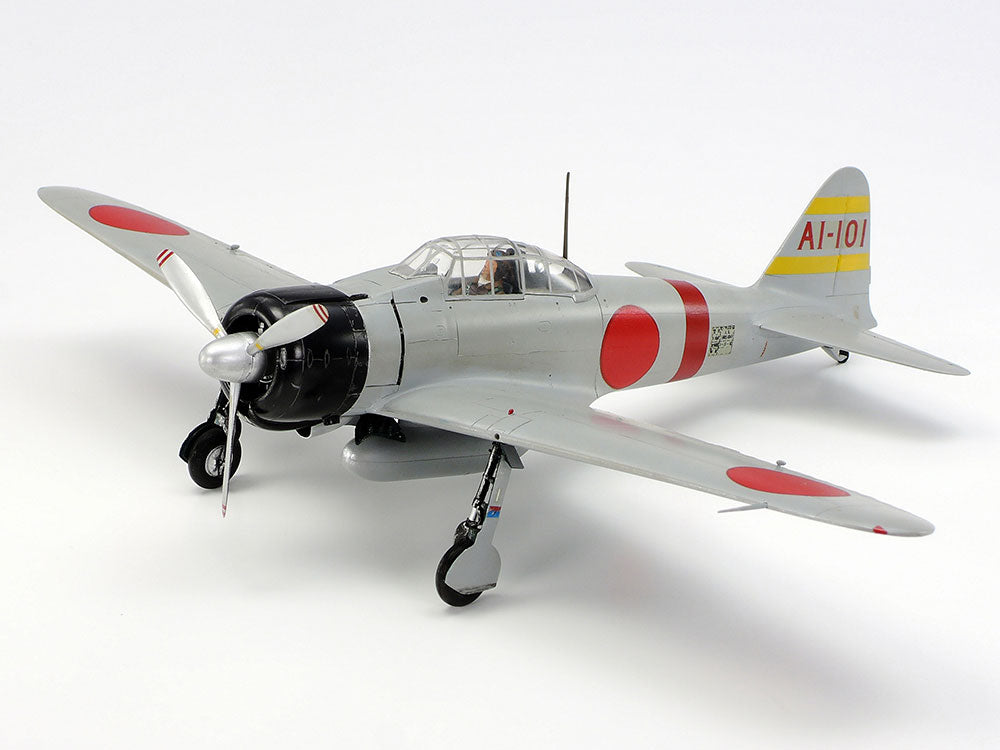 Tamiya Model of a World War II 1/48 Mitsubishi A6M2 Zero Fighter (Zeke) plane with red and yellow markings on a white background