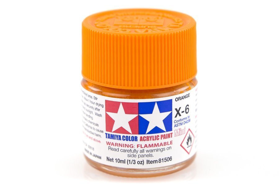 A small bottle of Tamiya acrylic paint in orange color, labeled X-6.