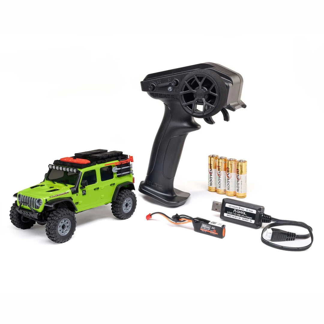 Green Axial SCX30 Jeep Wrangler JLU 1/30 RTR Rock Crawler Remote control car with black remote control, batteries, and charger on a white background