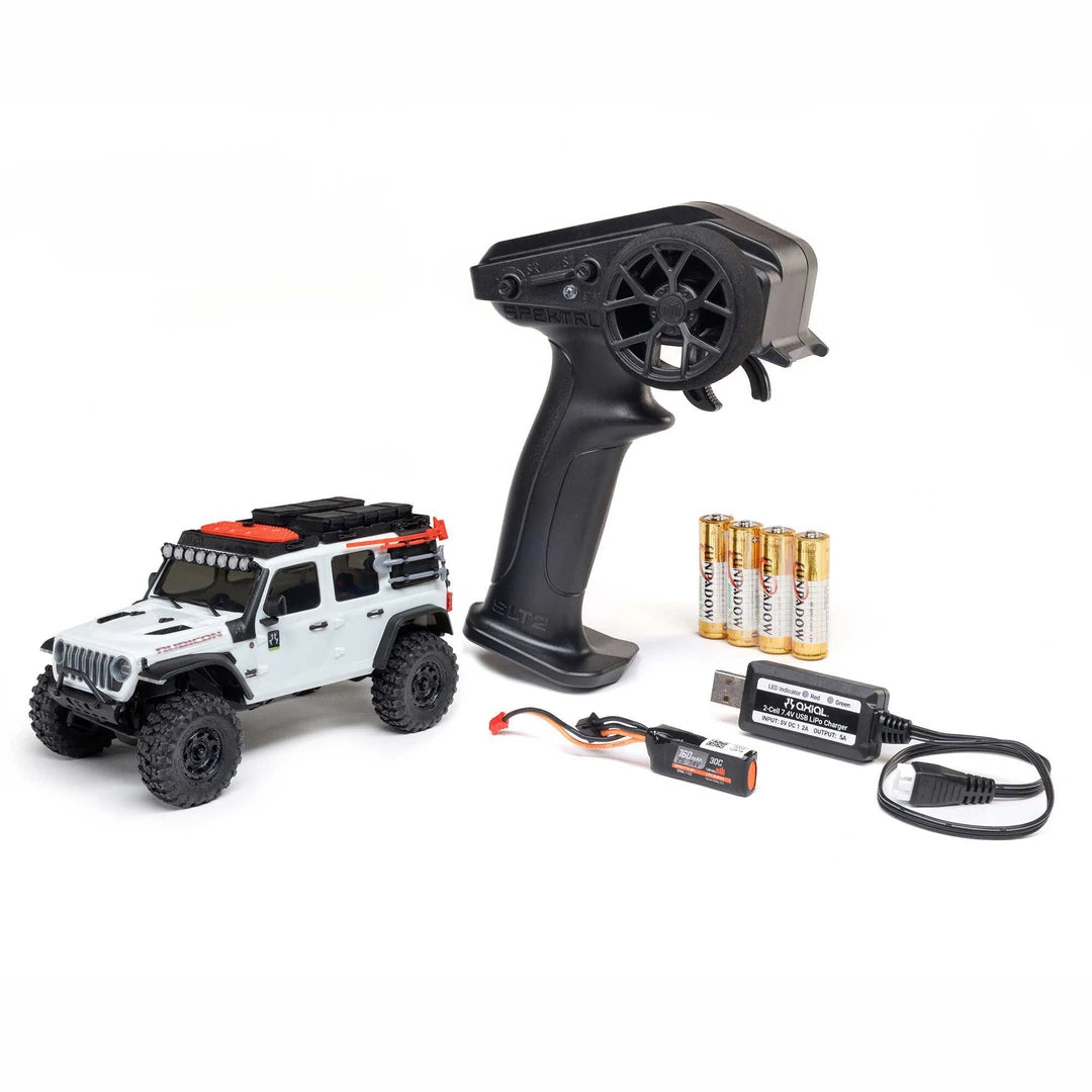 White Axial SCX30 Jeep Wrangler JLU 1/30 RTR Rock Crawler Remote control car with remote controller, batteries and charger on a white background