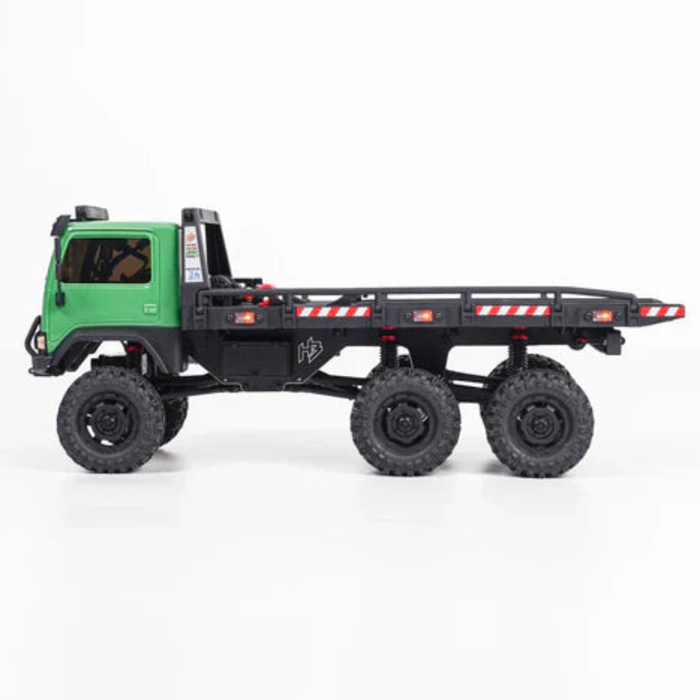Model truck with a green body and black chassis on a white background