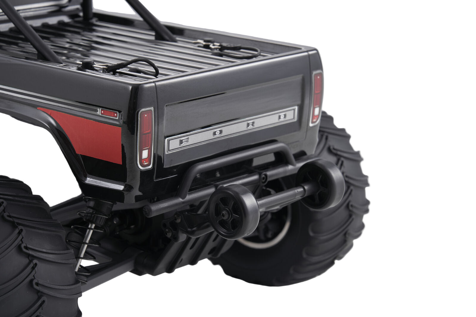 Close-up of a black off-road vehicle with red accents on a gray background