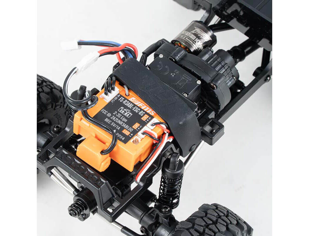 Close-up of an RC car chassis with battery and wiring on a white background