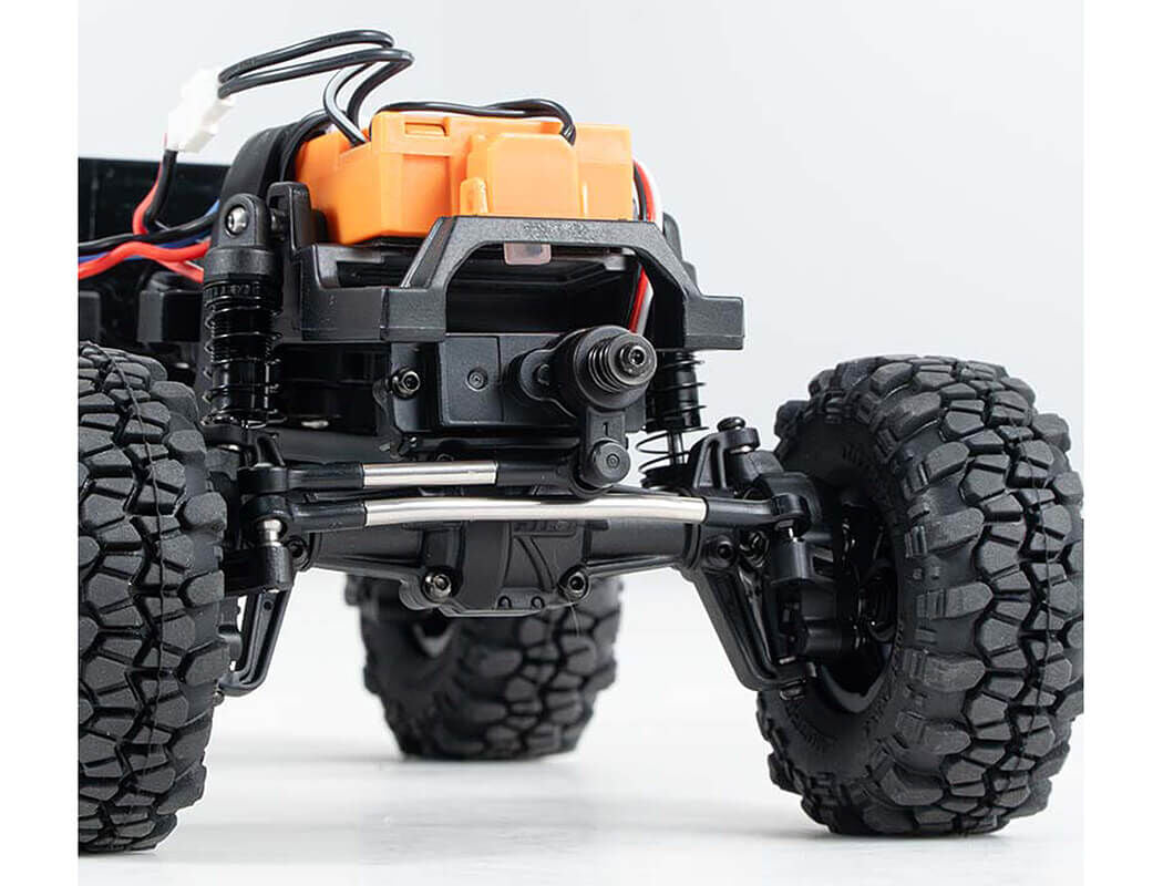 Close-up of a remote control car chassis with large wheels on a white background