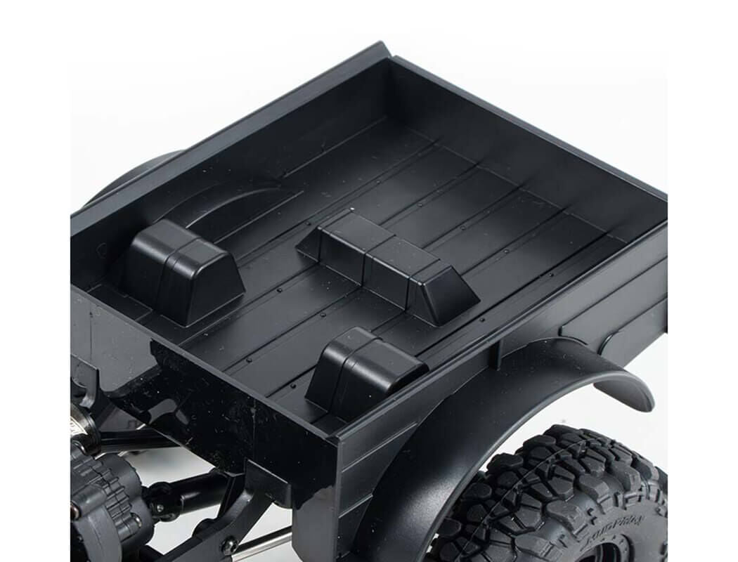 Close-up FMS Power Wagon Brushless Black off-road vehicle bed with tire and suspension components on a white background
