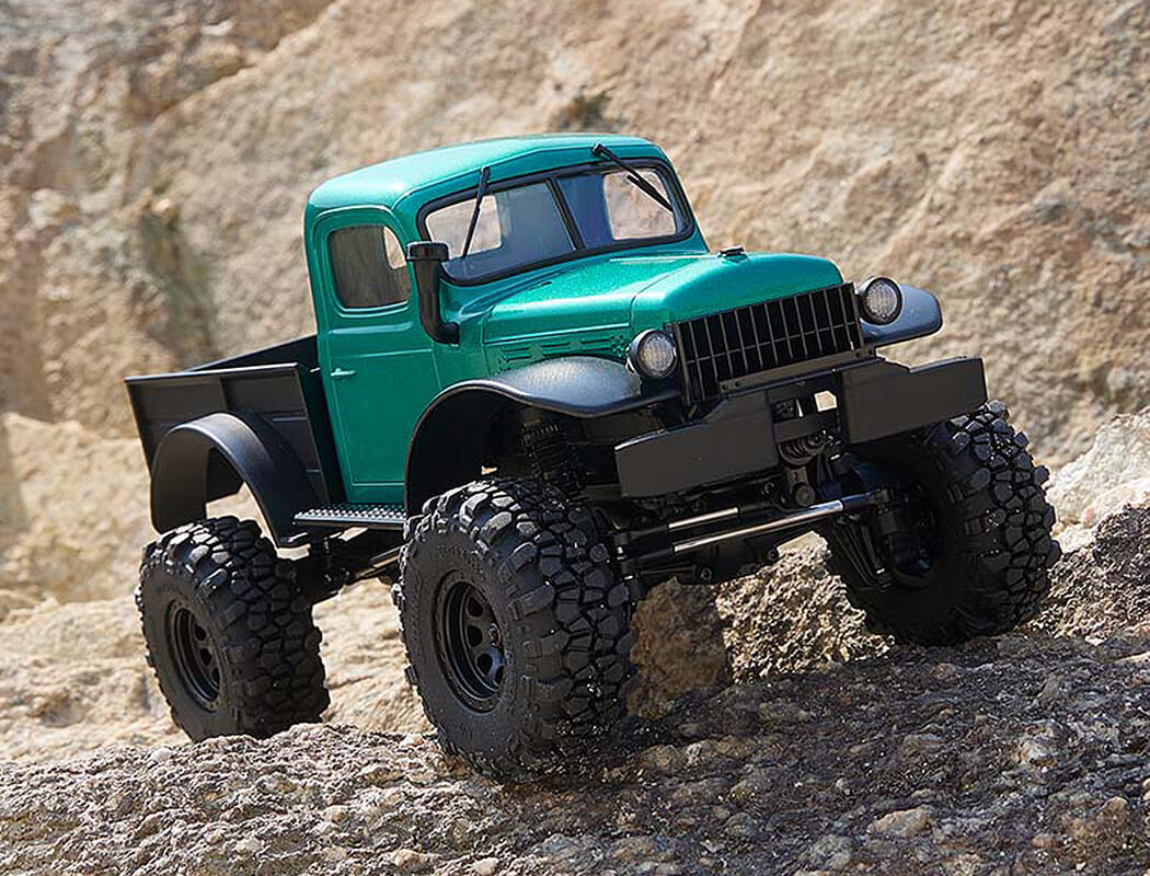 Green off-road FMS Power Wagon truck on rocky terrain