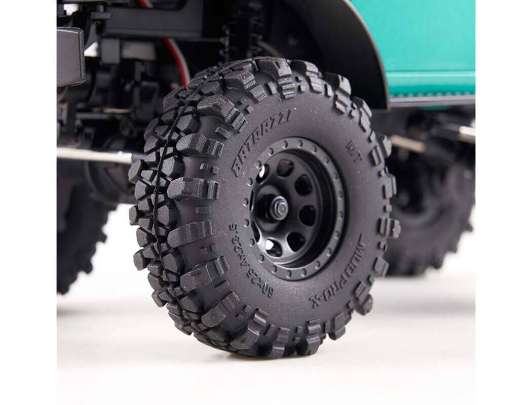 FCX24 Power Wagon Brushless RC Crawler Close-up of a black off-road tire with tread pattern on a white background