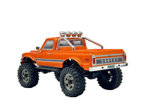 Orange toy truck with large wheels on a gray background