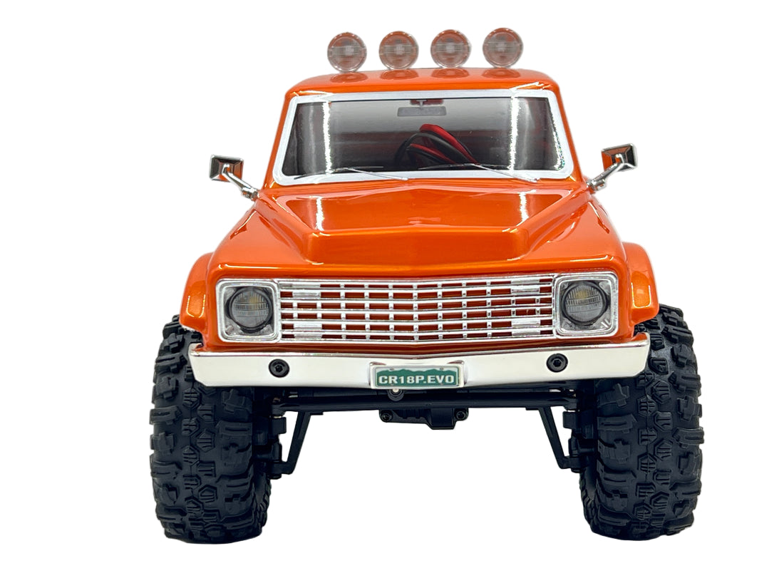 Orange off-road model truck with large tires on a gray background