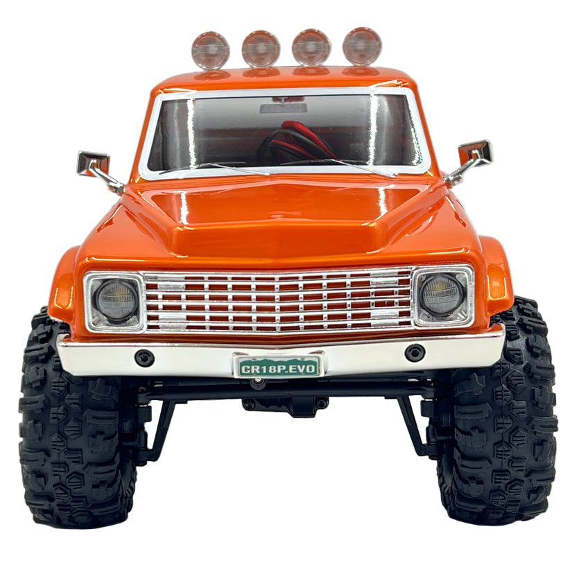 Orange off-road model truck with large tires on a gray background
