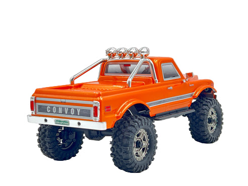 Orange model truck with large wheels on a gray background