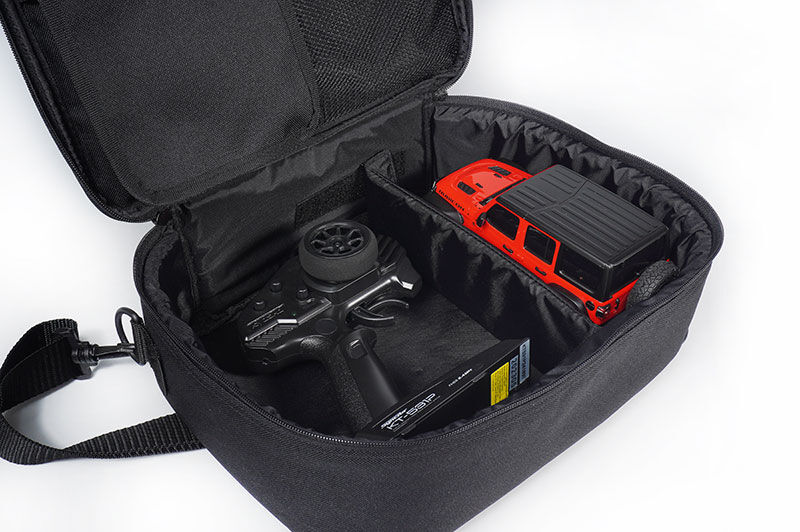 Black carrying case with remote control and battery on a white background