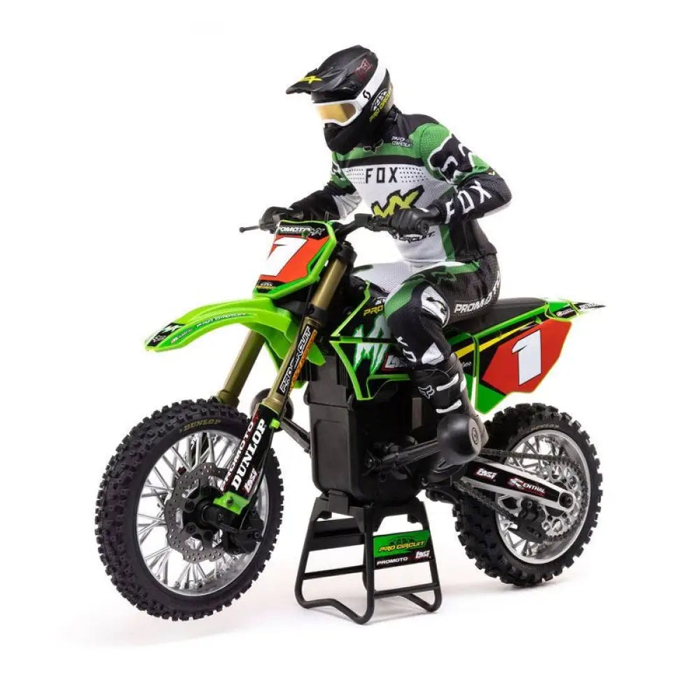 Model of a person on a green Losi Promoto-MX 1/4 Dirt Bike with sponsor logos on a white background