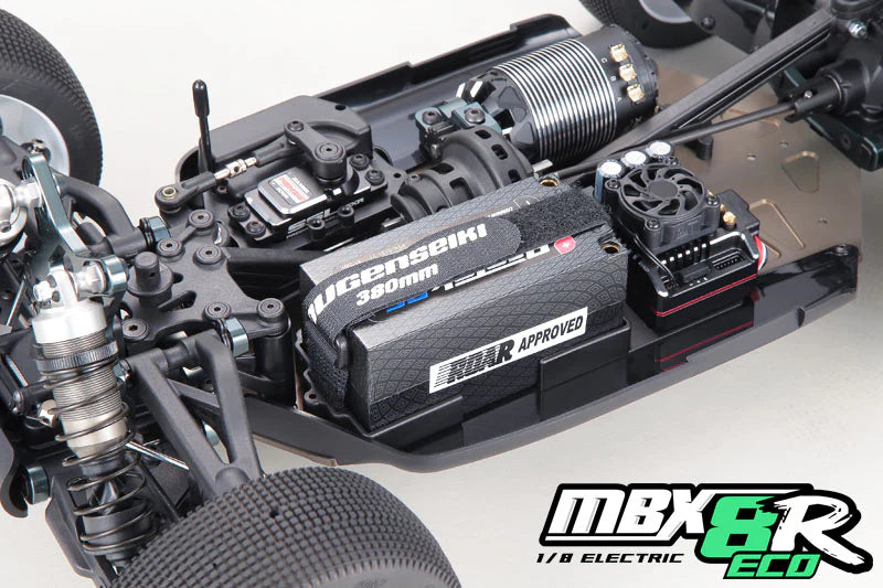Close-up of a Mugen MBX8R-ECO RC car car chassis with electronic components and branding on a gray background.