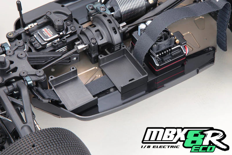Close-up of a Mugen MBX8R-ECO RC car chassis with electronic components on a white background, featuring the MBX8R ECO branding.