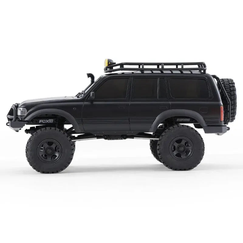 Black off-road vehicle with large tires and a roof rack on a white background