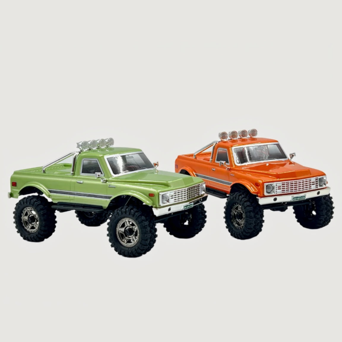 Two Hobby Plus CR18P EVO V2 Convoy RC trucks, one green and one orange, on a white background