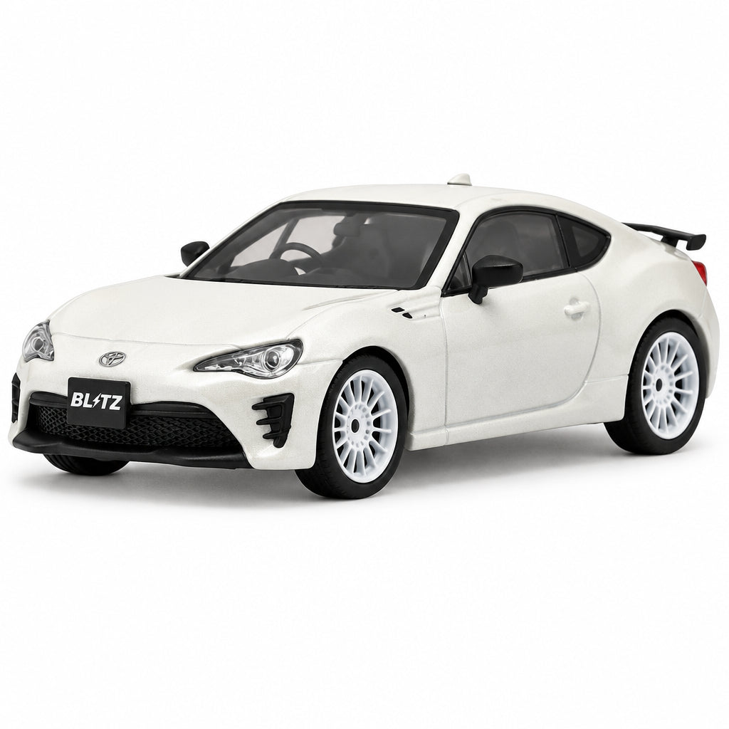 A white die-cast model car of a Toyota 86 BL-TZ, featuring a glossy white body, black front splitter and side mirrors, and white multi-spoke wheels, shown on a plain white background.
