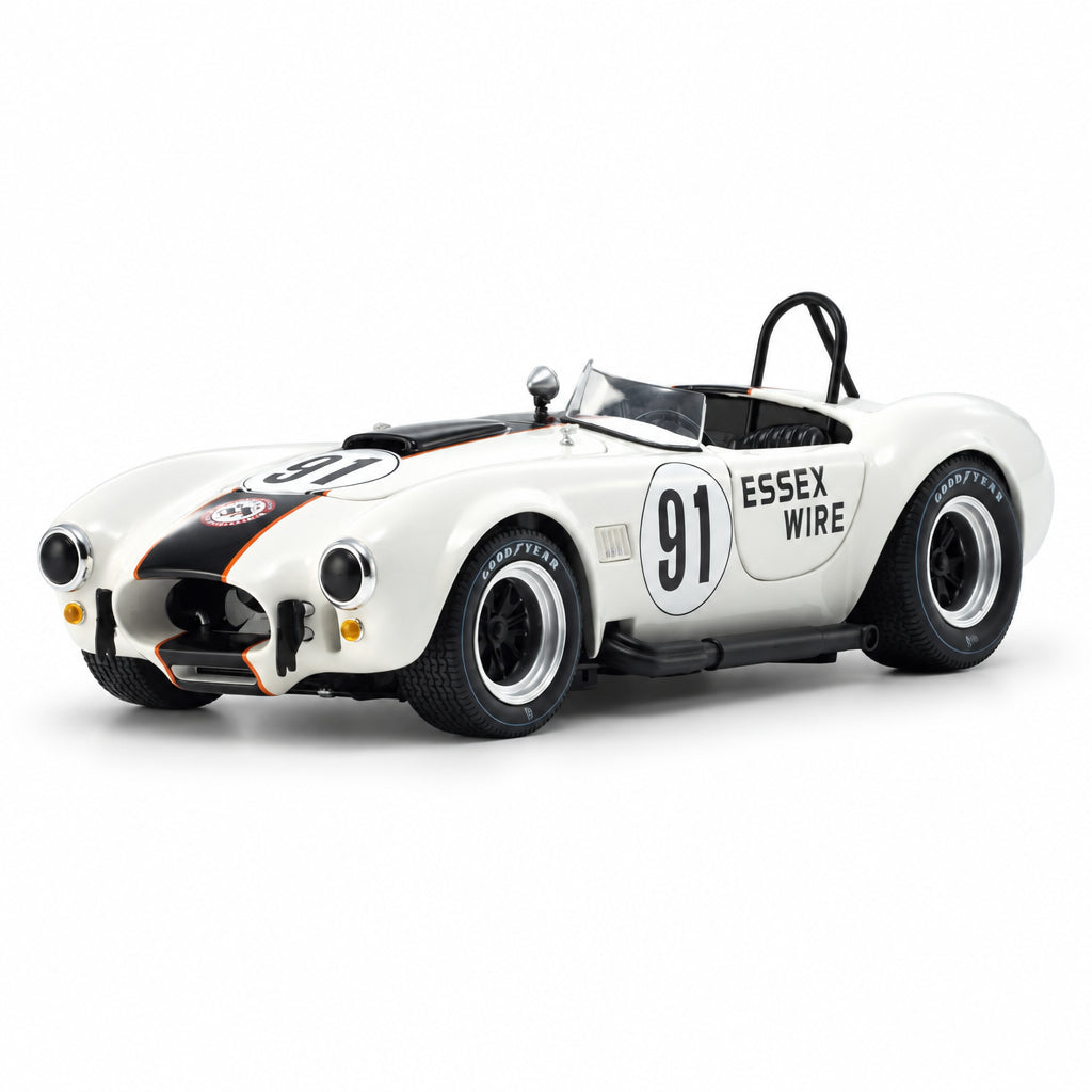 A diecast model of a classic white Shelby Cobra race car with black and orange livery, featuring '91' and 'ESSEX WIRE' markings, on a white background.