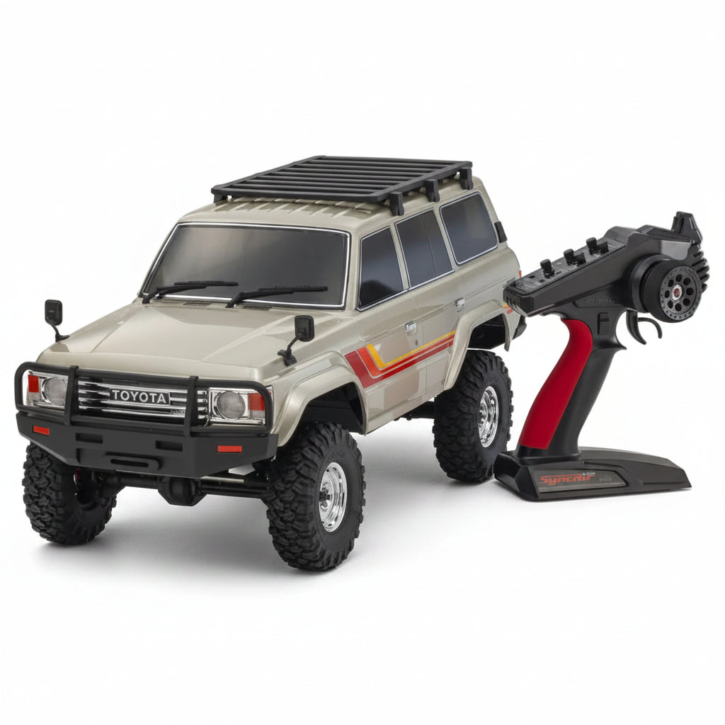 A Gold Kyosho KC10 Toyota Land Cruiser 60 1/10 4WD RC Electric Rock Crawler with a black and red remote control on a white background