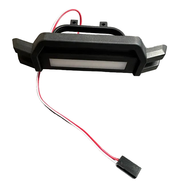 Black electronic component with red and white wires on a gray surface