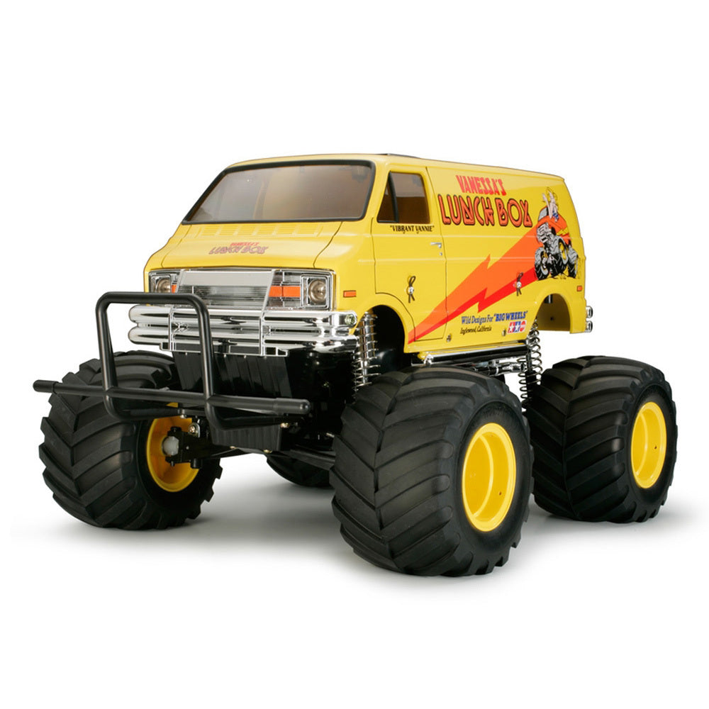 TAMIYA LUNCH BOX monster truck with a yellow van body and large truck wheels on a white background