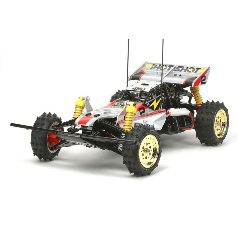 A Tamiya Super Hotshot remote control car with a silver body, black and orange detailing, and gold metal-plated wheels.