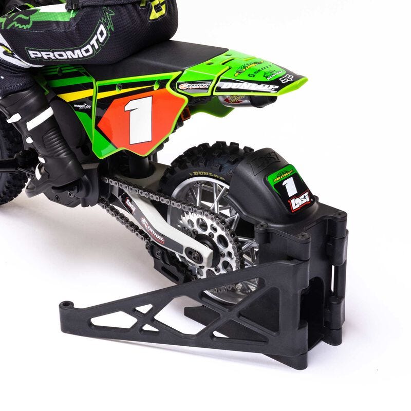 Close-up of a green and black dirt bike with visible branding on a white background